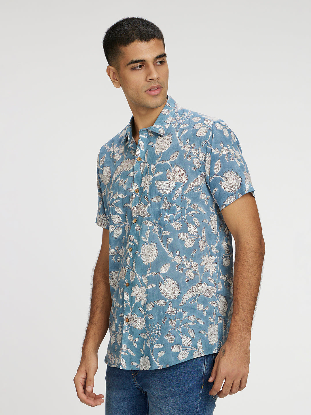 Model Facing sideways wearing Blue Floral Block Printed Holiday Halfsleeves Mulmul Cotton Shirt by Brand Patrah