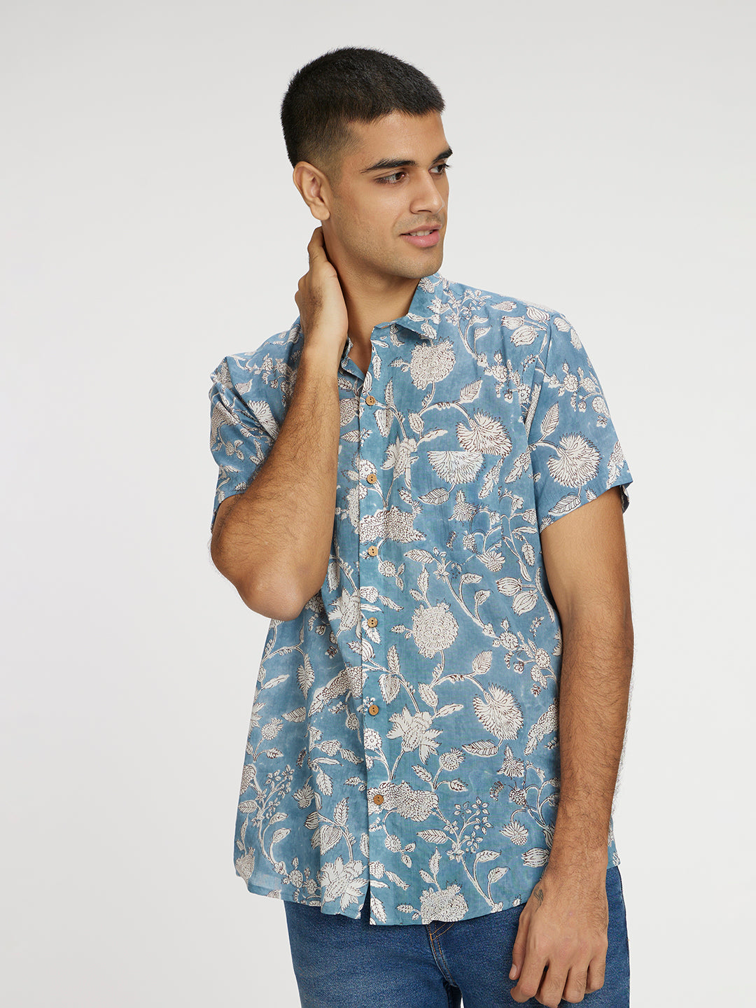 Model Facing sideways wearing Blue Floral Block Printed Holiday Halfsleeves Mulmul Cotton Shirt by Brand Patrah