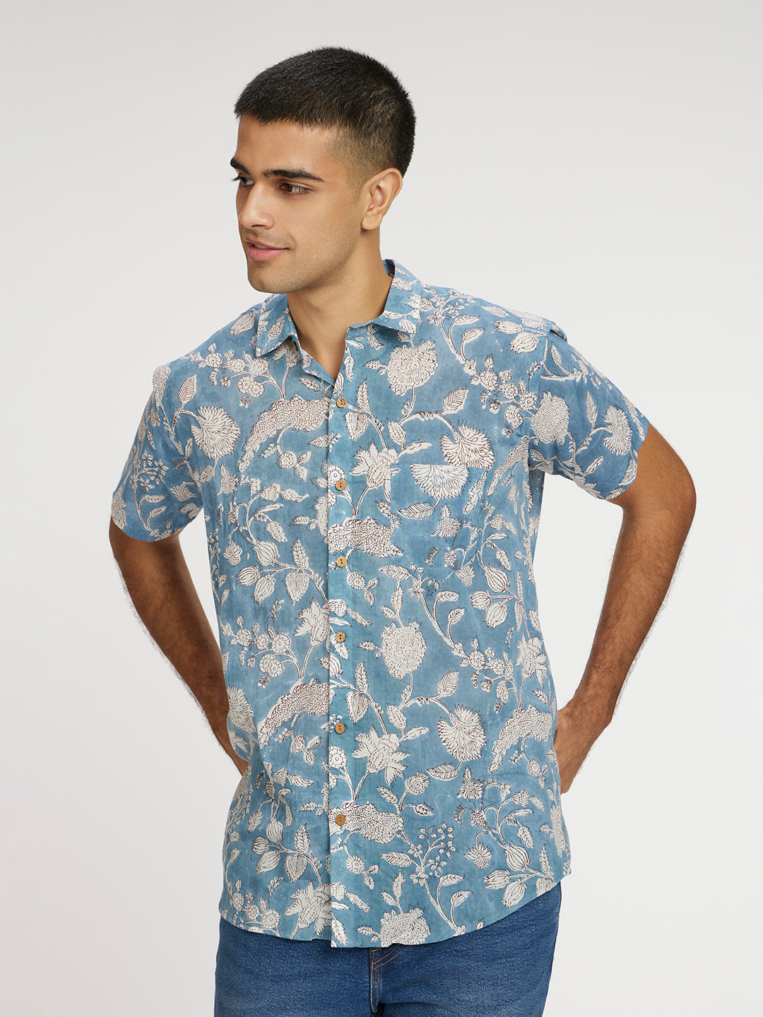 Model Facing sideways wearing Blue Floral Block Printed Holiday Halfsleeves Mulmul Cotton Shirt by Brand Patrah