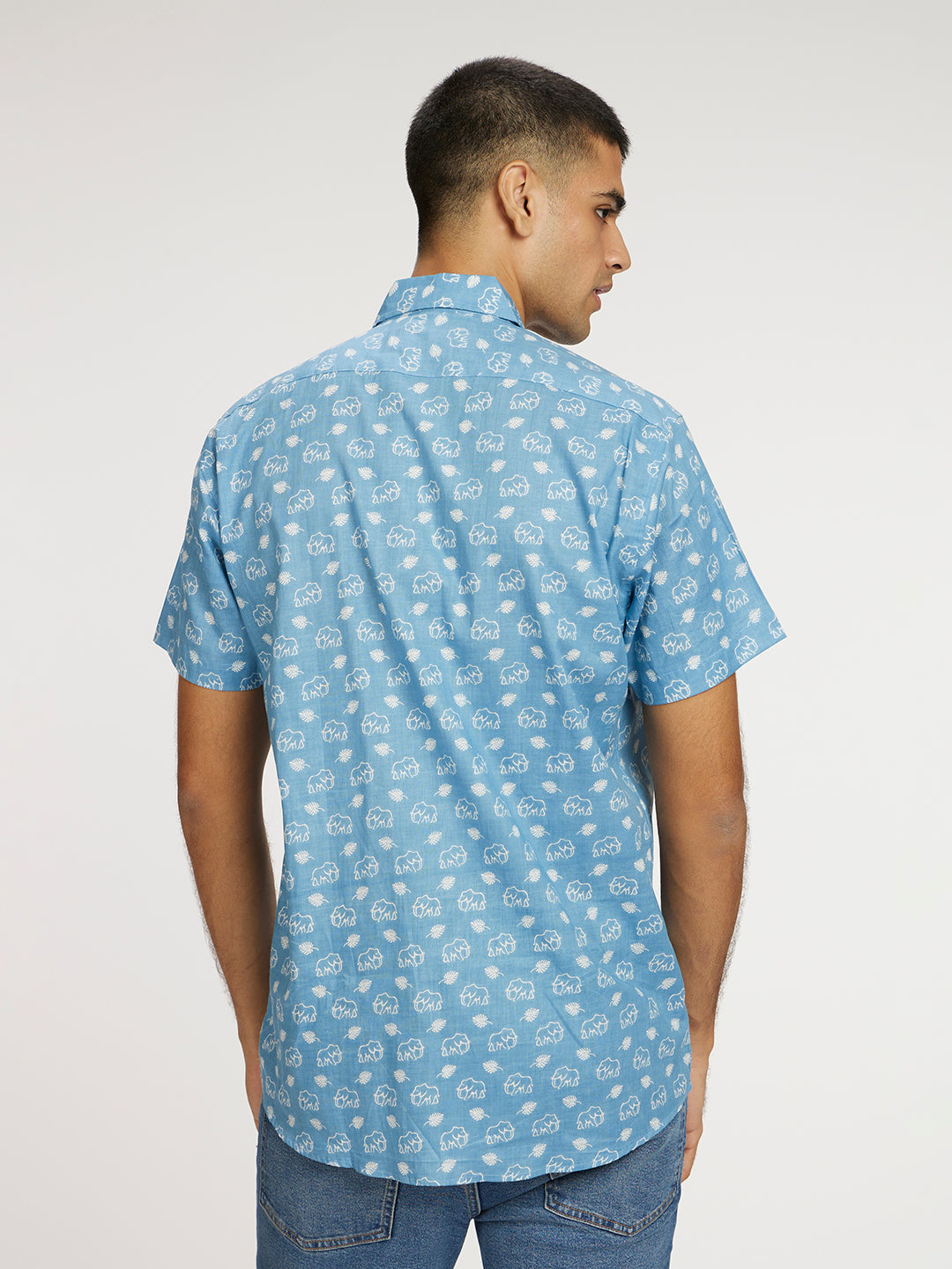 Model facing backwards wearing Blue skies white elephant printed Halfsleeves Cotton Shirt by Brand Patrah