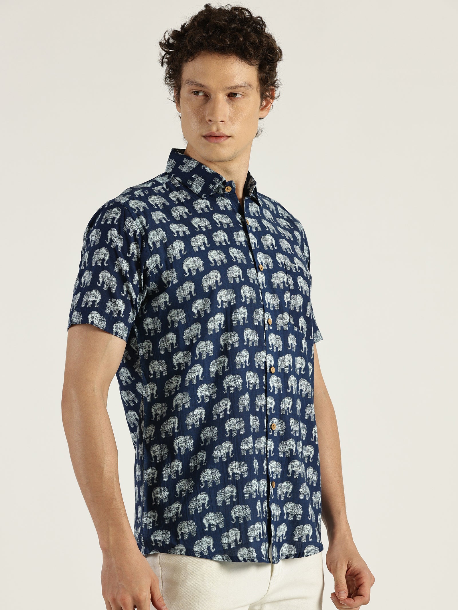 Model Facing sideways wearing Indigo Ethnic Elephant Printed Halfsleeves Cotton Shirt by Brand Patrah