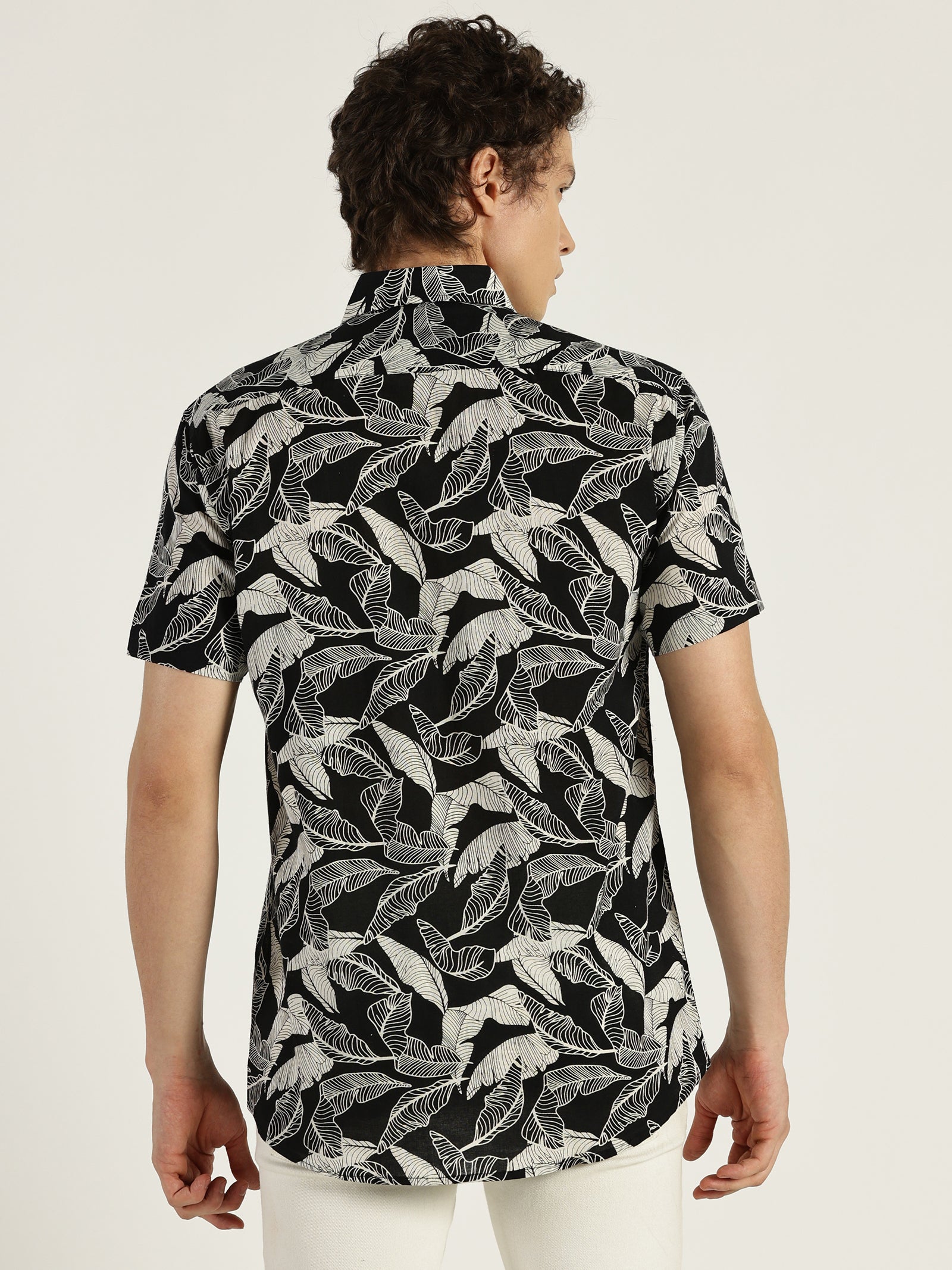 Model facing backwards wearing Tropical Leaf Black Printed Halfsleeves Cotton Shirt by Brand Patrah