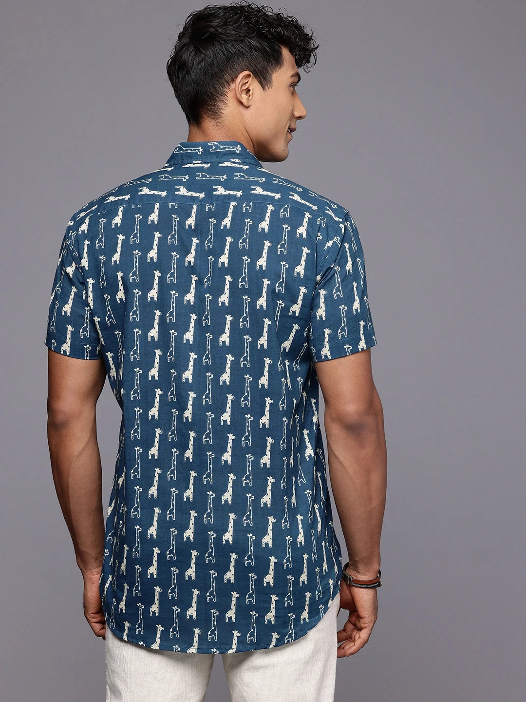 Back view of blue giraffe cotton shirt styled for holidays