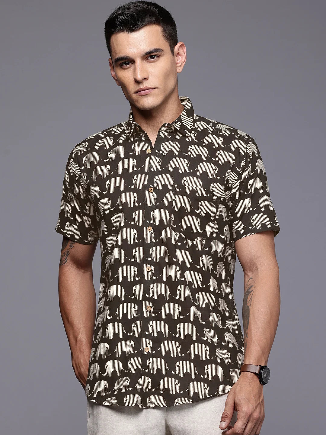 Man wearing a black shirt with elephant pattern.