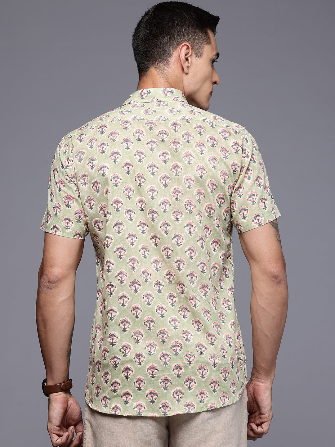 Man wearing a patterned shirt with back print.