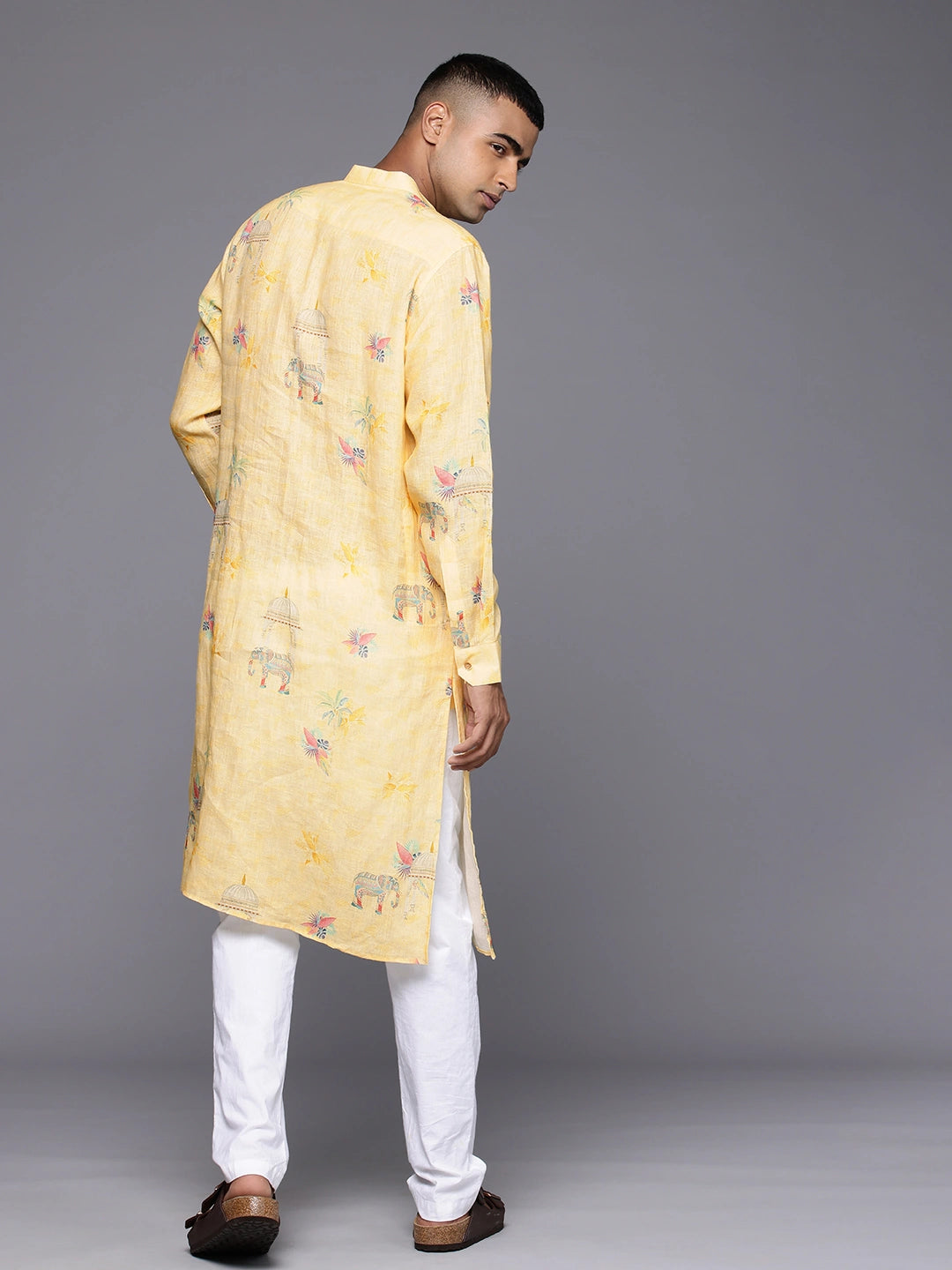 Model facing backwards wearing Yellow Elephant Print linen Kurta by Brand Patrah