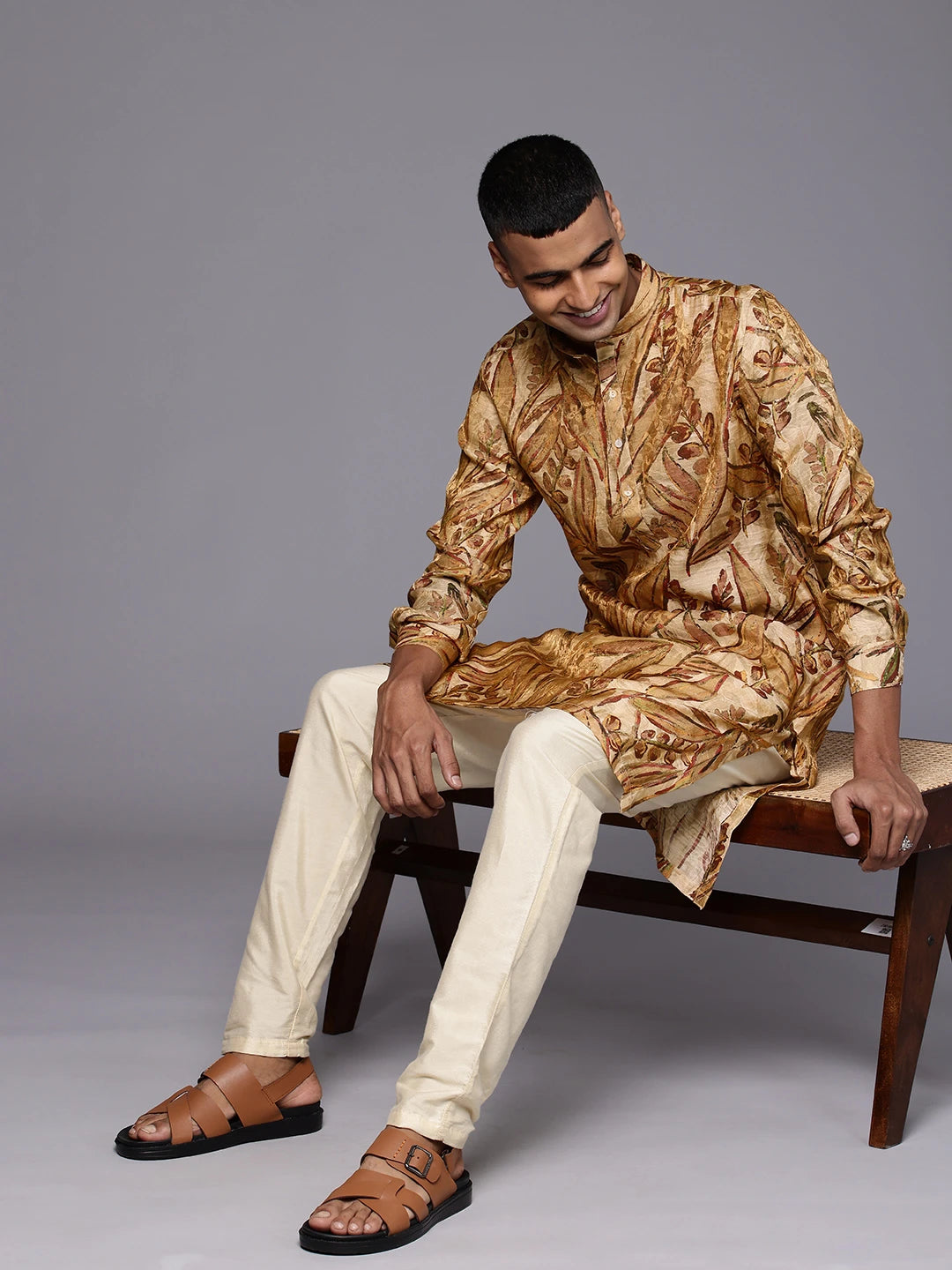Black Model sitting on a chair wearing Golden Maroon Abstract Floral Print Silk Kurta by Brand Patrah