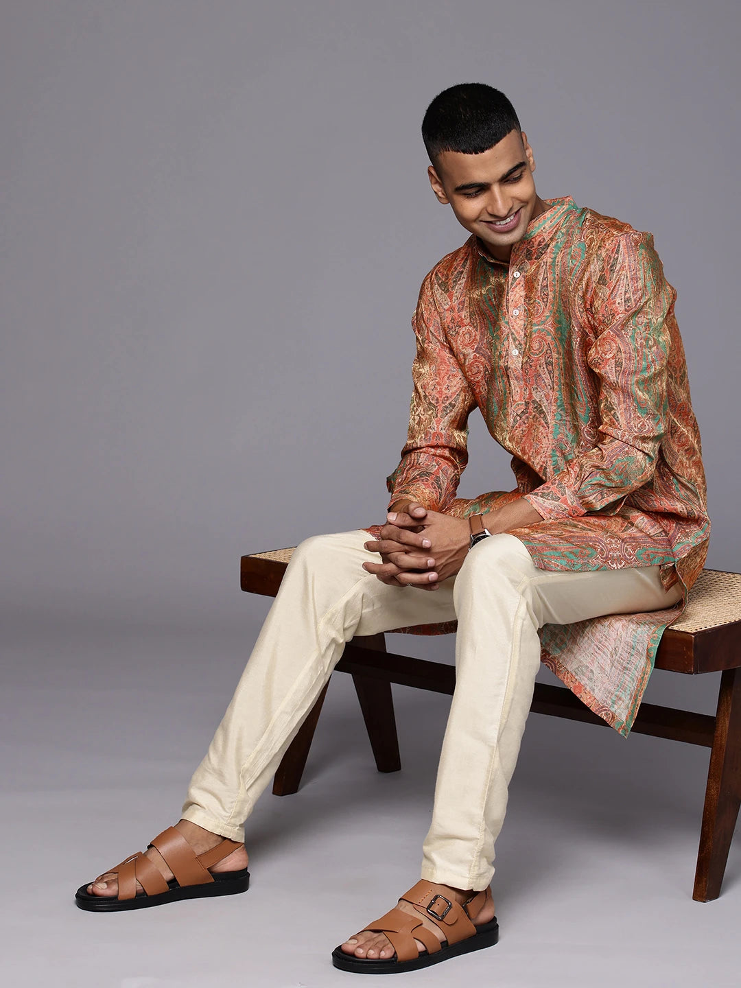 Black Model sitting on a chair wearing Paisely Green Abstract Print Silk Kurta by Brand Patrah