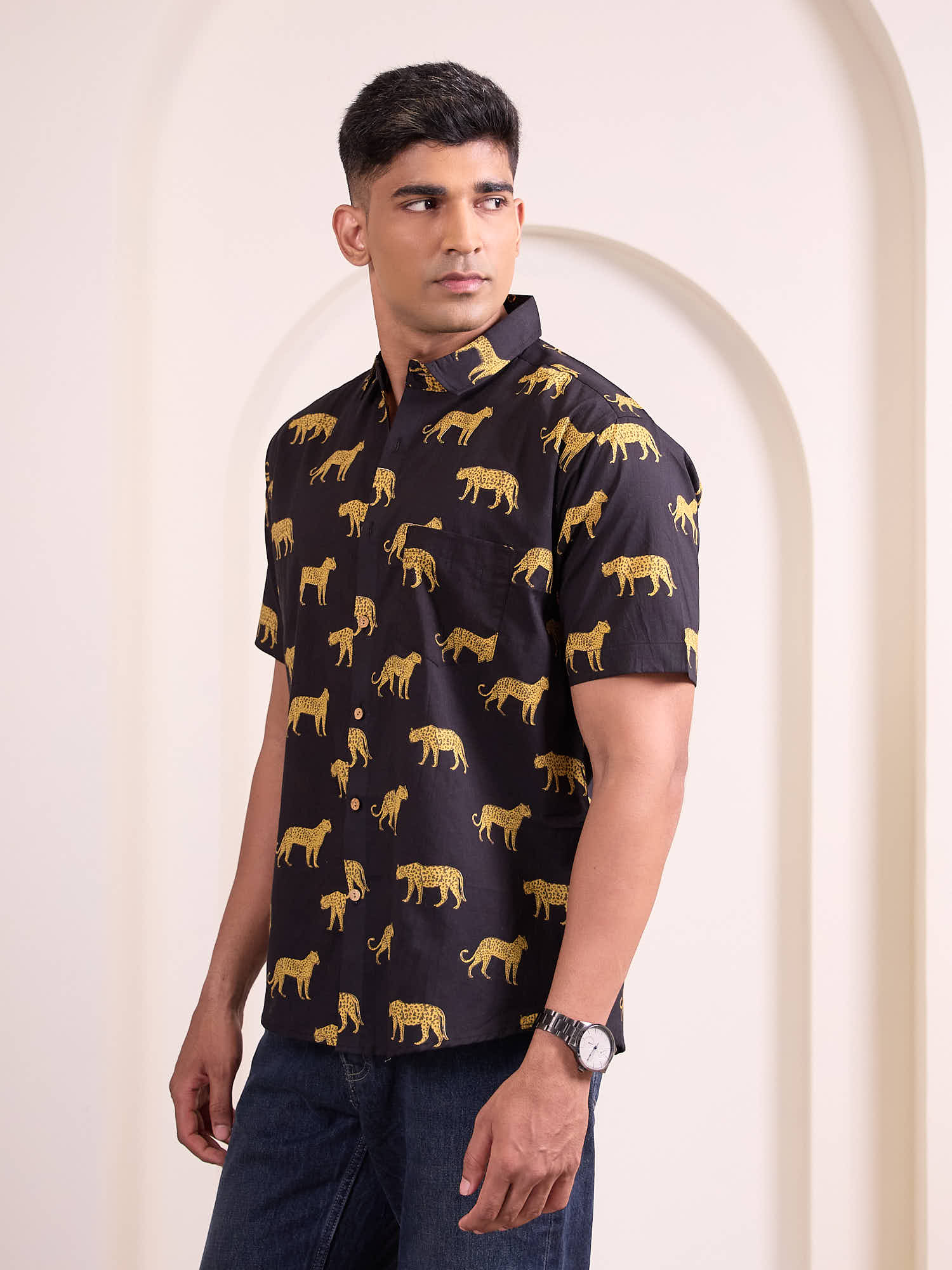 Model wearing a black shirt with gold cheetah animal print shirt against a white background