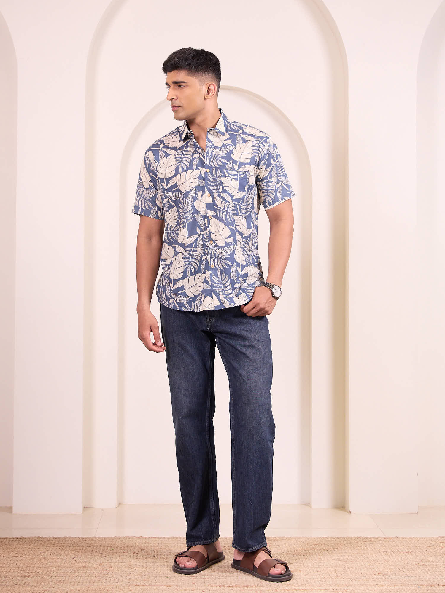 Men model wearing short sleeve floral printed shirt with blue jeans