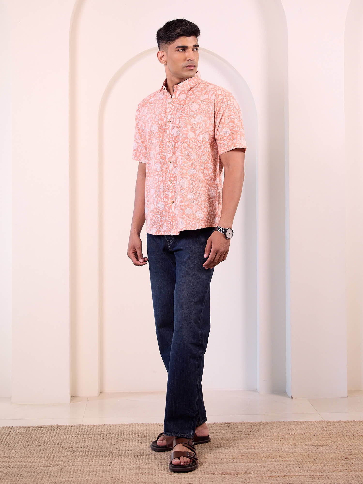 Men model wearing short sleeve floral printed shirt with blue jeans