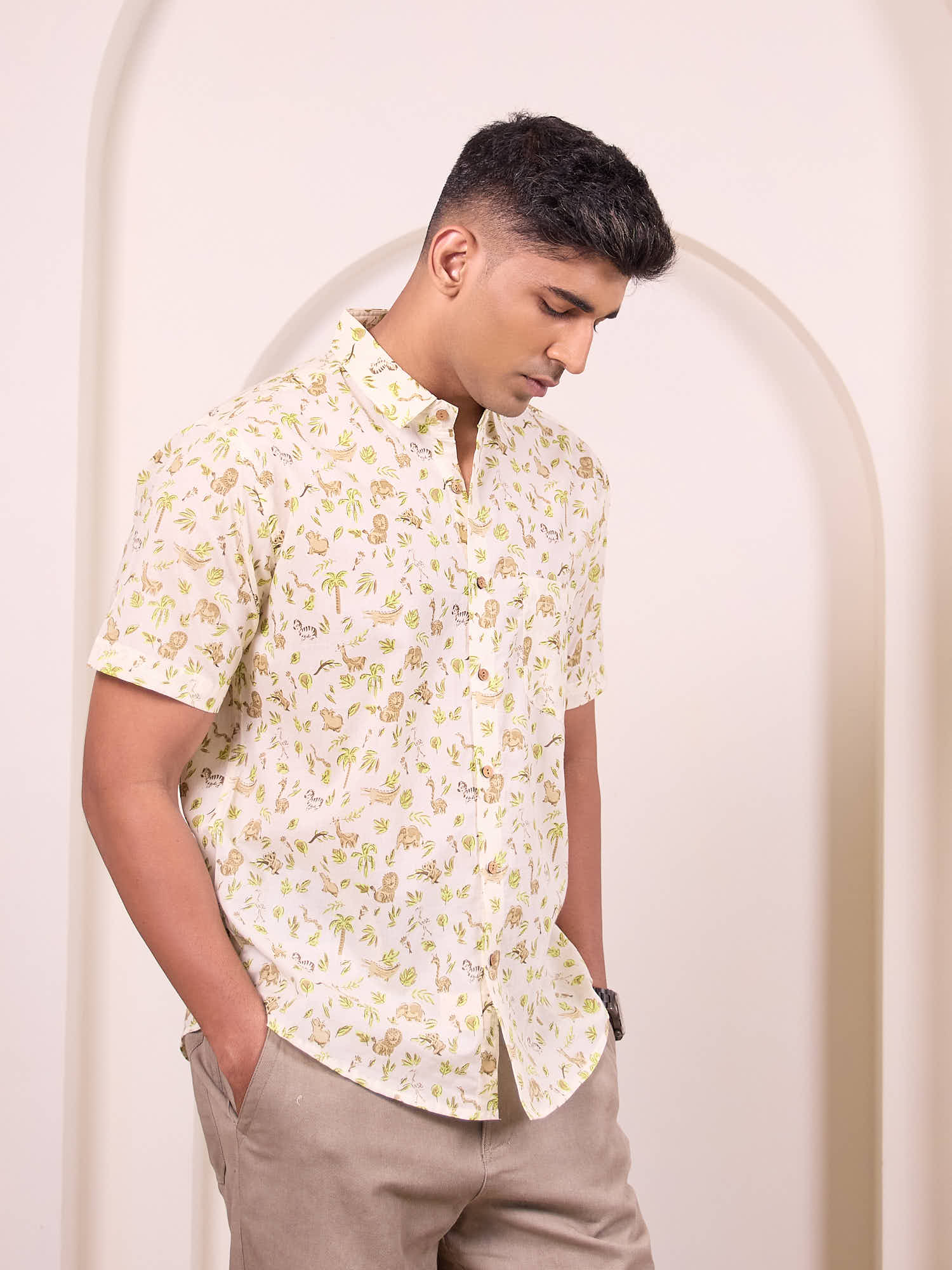 Man wearing a white floral shirt against a plain background