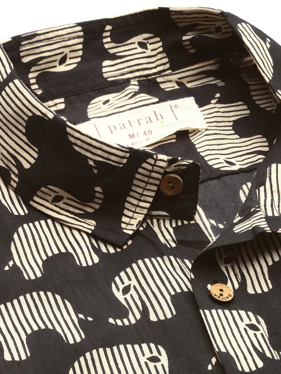 Black shirt with white elephant pattern and patrah. 