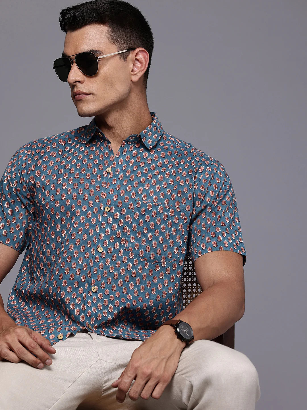 Man wearing a blue short-sleeved floral cotton shirt