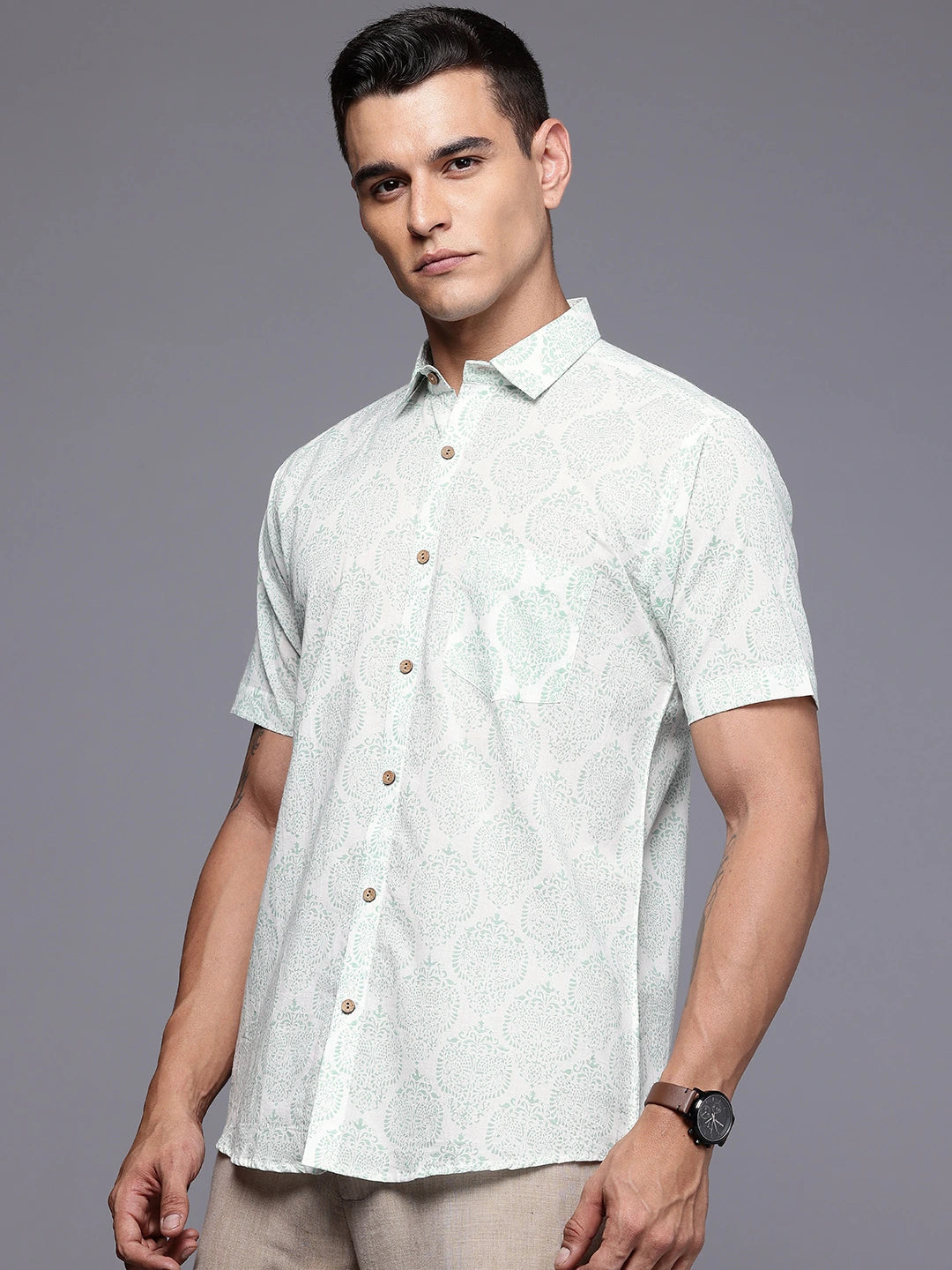Man wearing a light-colored short-sleeve  printed shirt 